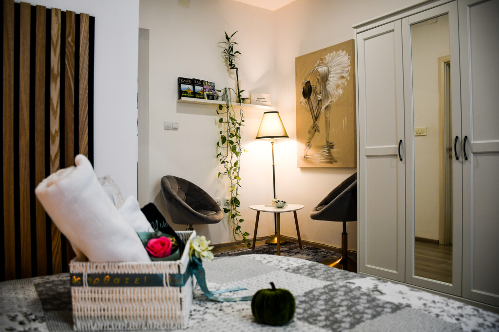 Kutak za odmor sa stolom, dvije fotelje i zelenilom u apartmanu.