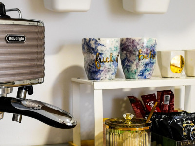 Set kave, čajeva i dizajnerskih šalica na kuhinjskom stolu.