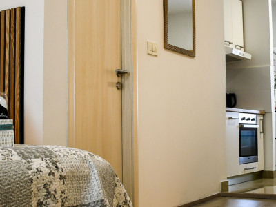 Moderno uređena soba s TV-om na zidu i pisaćim stolom ispod.