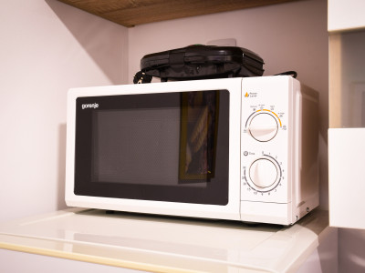 Mikrovalna pećnica u čistoj i jednostavnoj kuhinji apartmana