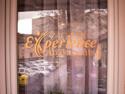 Prozor s natpisom "Apartments Experience Zagreb"