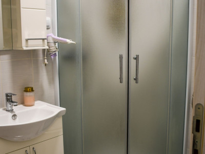 Moderno uređena kupaonica s tuš kabinom i staklenim pregradama.